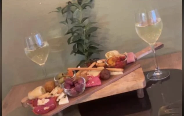 Planche à partager sur une table de la salle, un verre de vin blanc de chaque côté