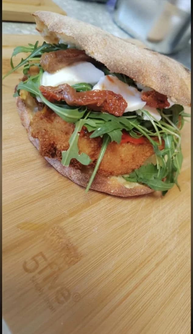 Puccia garnie de poulet pané, roquette, tomates séchées et sauce blanche
