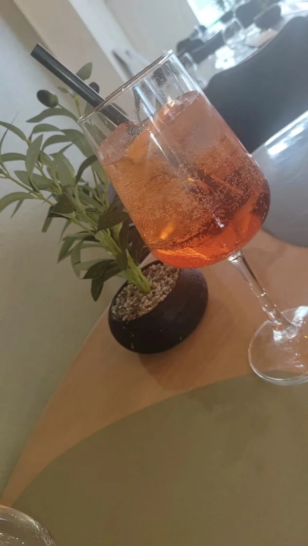 Spritz servi en salle, à côté d'un olivier en pot